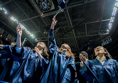 Penn State graduates tossing caps