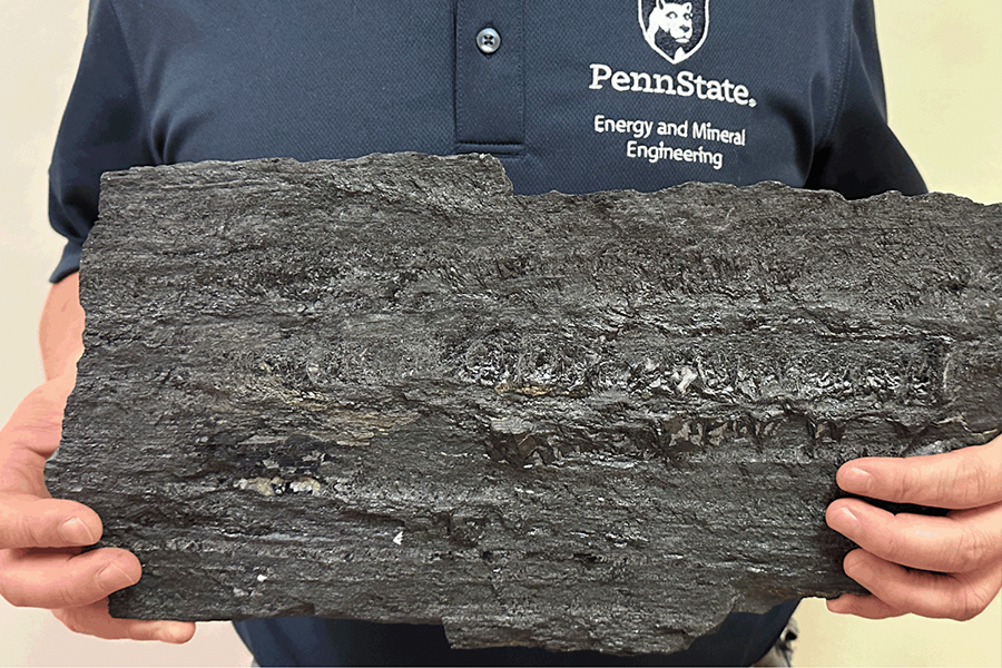 Penn State researcher holds a large piece of coal